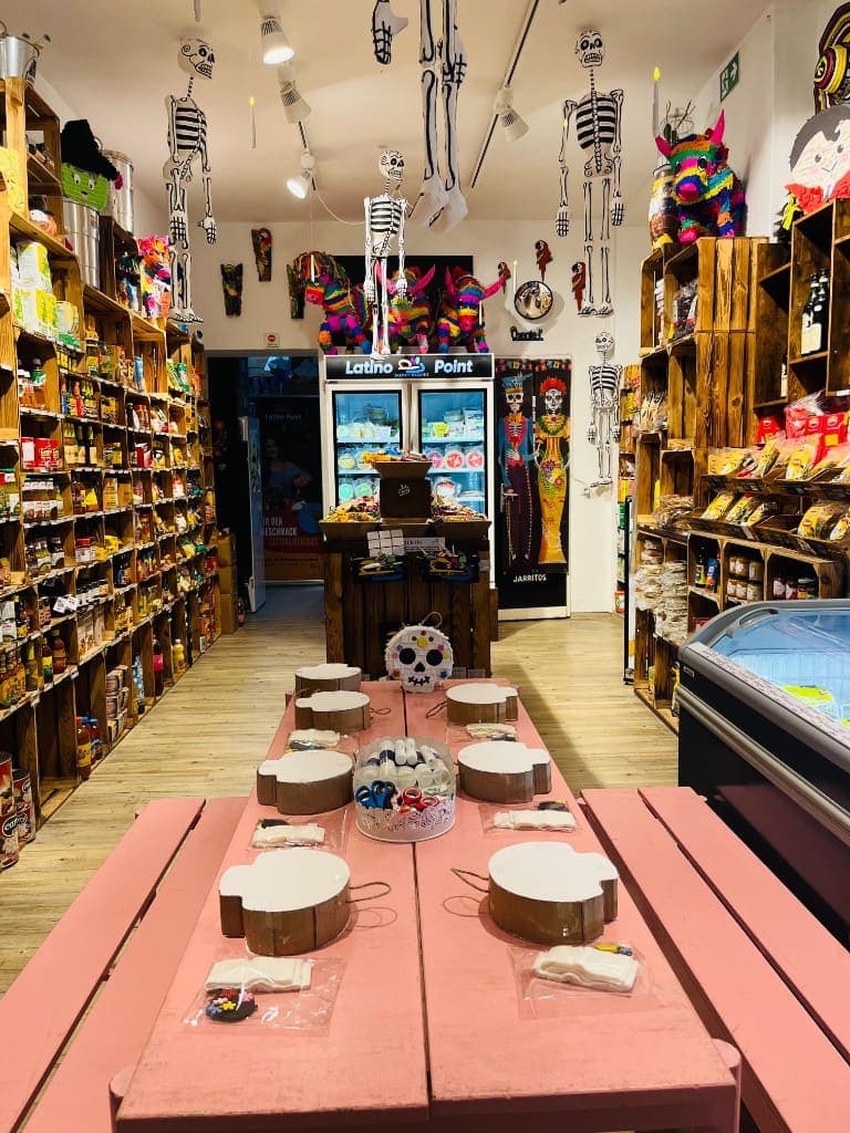 A pink workshop table prepared with piñata bases and materials inside Latino Point